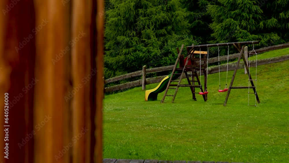 Children empty playground with swing and slide on idyllic mountain hut in Austria Children empty playground with swing and slide on idyllic mountain hut in Austria