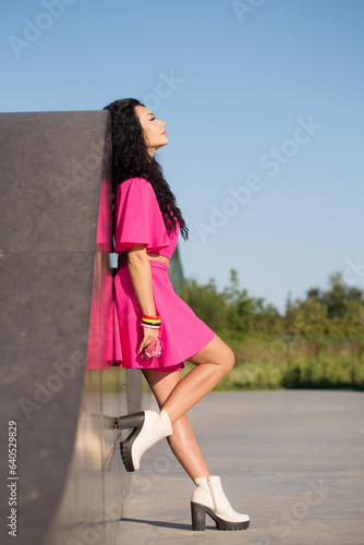 Pensive beautiful woman in a pink outfit