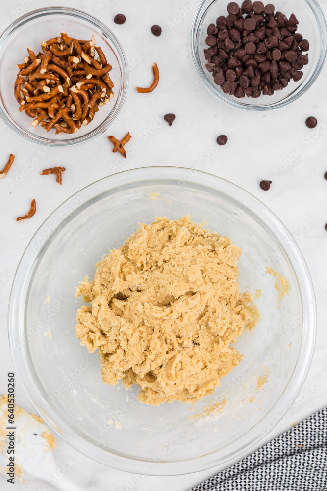 Cookie dough in bowl with pretzels and chocolate chips flatlay Cookie dough in bowl with pretzels and chocolate chips flatlay