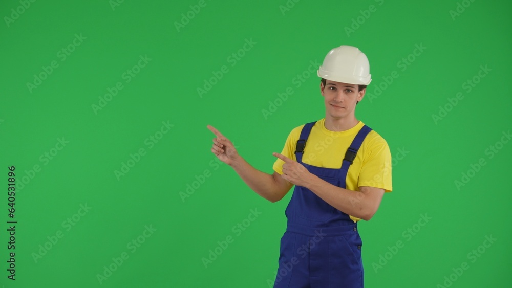 Medium green screen isolated chroma key shot of a young construction worker pointing to the side of the frame. Medium green screen isolated chroma key shot of a young construction worker pointing to the side of the frame.