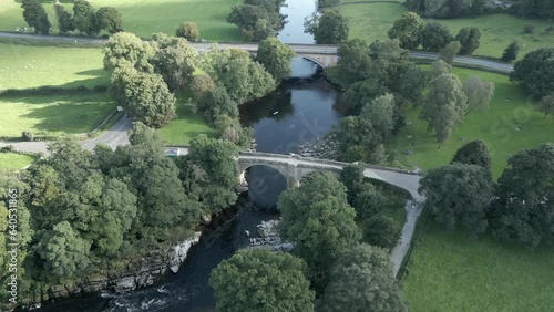 An aerial view of the Devil's Bridge at Kirkby Lonsdale on a summer evening, Yorkshire, England, UK. Flying right to left around the northerly side of the bridge. photo