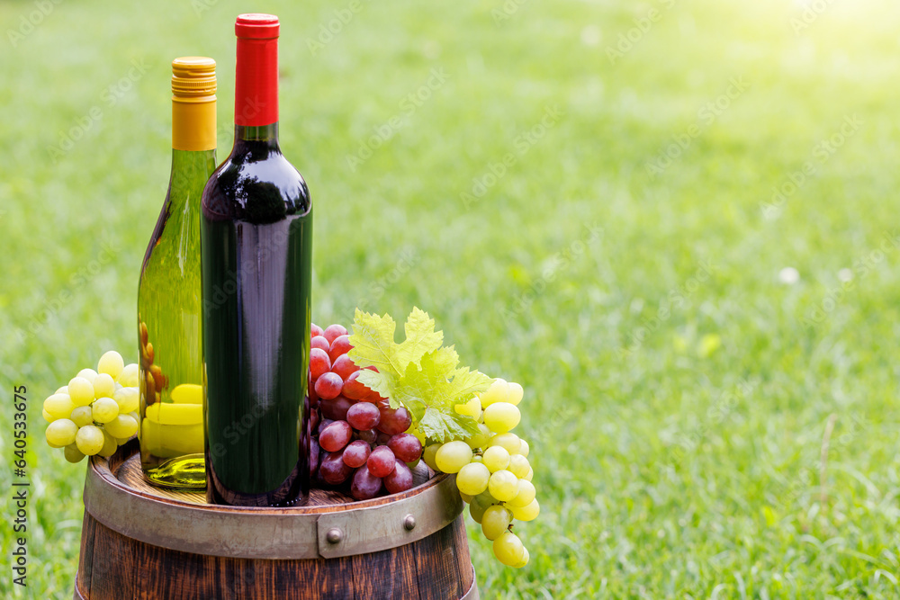 Obraz premium Wine bottles and grape on barrel