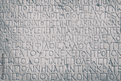 Historical inscription (the text of law at Ancient Greek language). Carving on marble block. Selcuk, Turkey (Turkiye). Retro background, monochrom, toning