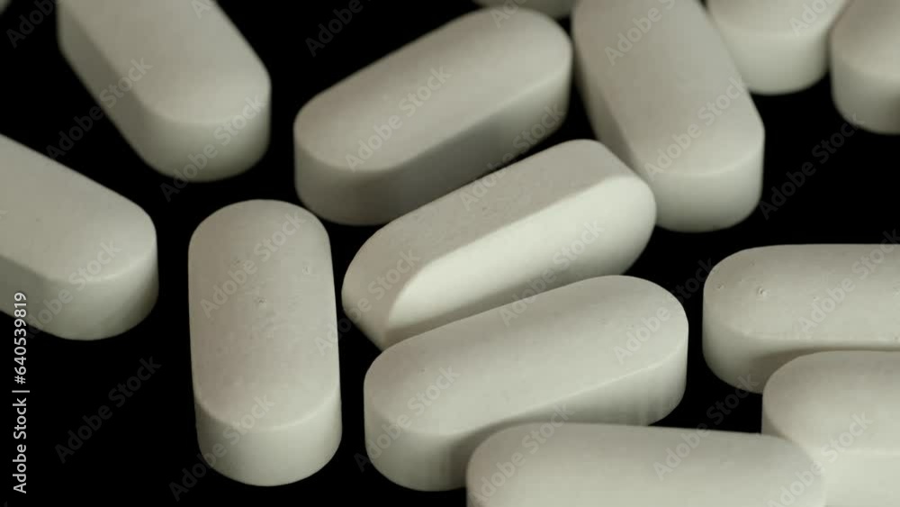 lot of white oblong pills close-up. Pharmaceutical Industry. Vitamins, antipyretics and contraceptives. Medical care. lot of white oblong pills close-up. Pharmaceutical Industry. Vitamins, antipyretics and contraceptives. Medical care.