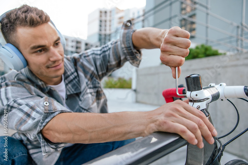 Young guy looking concentrated while repairing a bike