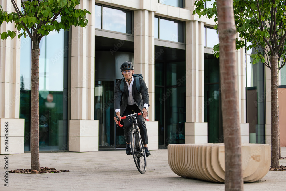 Fototapeta premium Man in hemlet on a bike in the office area