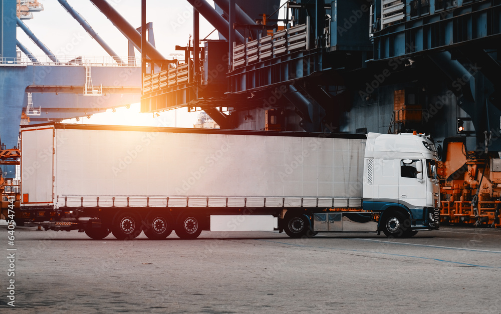 Fototapeta premium Truck isolated. Vehicle isolated. Commercial transport. Semitrailer during loading the cargo. Modern semi-trailer trucks on the highway. Commercial vehicle for shipping and post delivery.