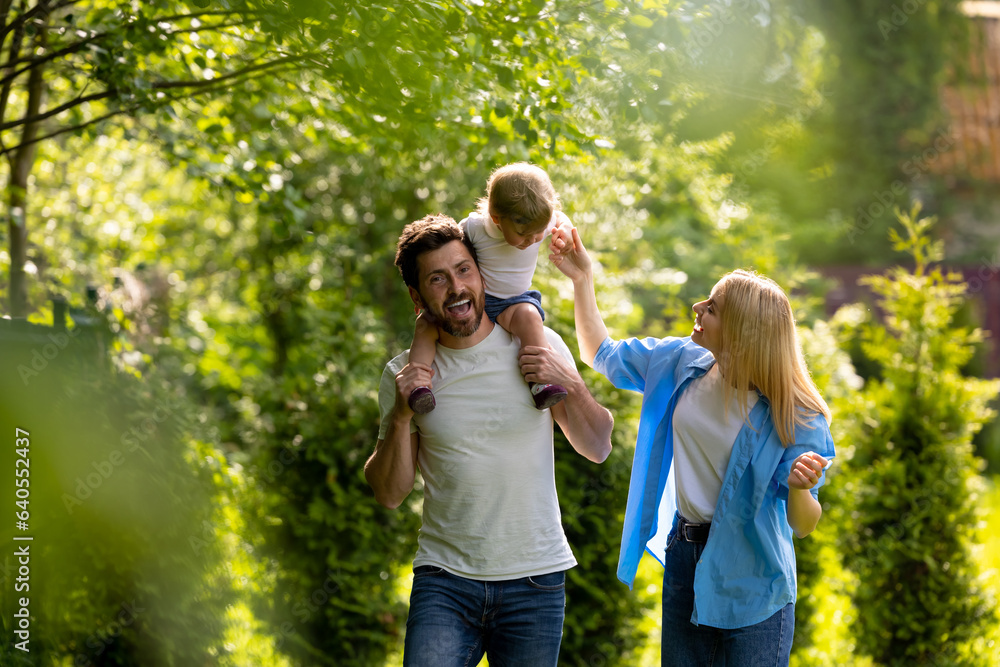 Fototapeta premium Parents and their cure kid spending time in the park