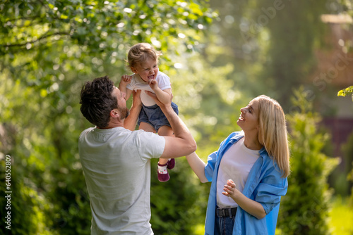 Happy parents spending time together with their kid outdoors