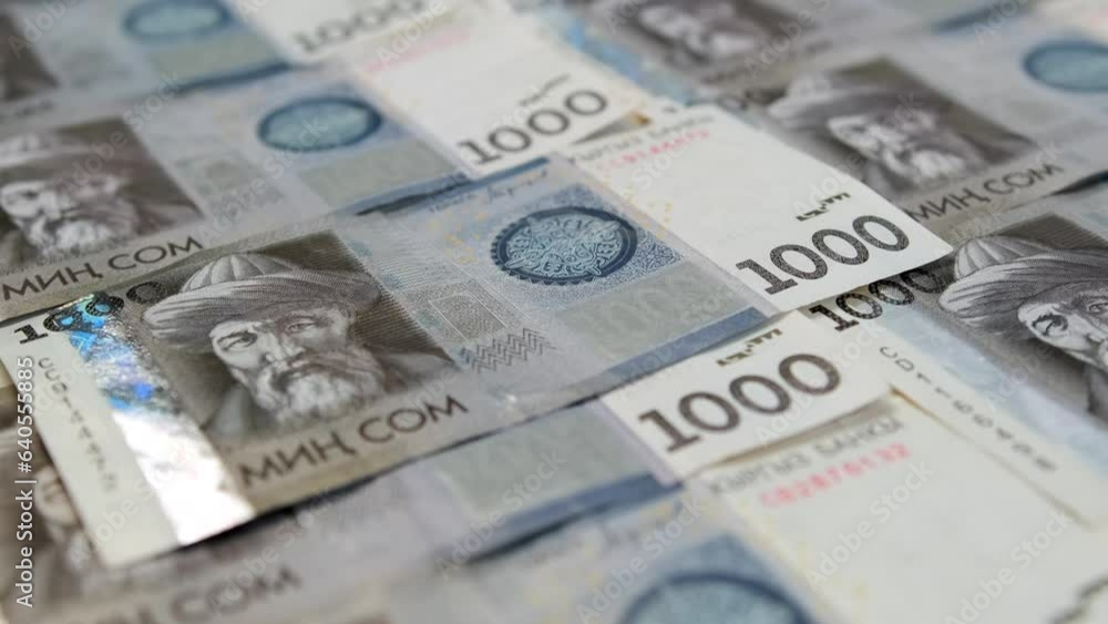 Many banknotes of 1000 Kyrgyz som neatly laid out cash on table. One thousands som money business background. National currency Republic of Kyrgyzstan. Financial success and abundance. Many banknotes of 1000 Kyrgyz som neatly laid out cash on table. One thousands som money business background. National currency Republic of Kyrgyzstan. Financial success and abundance.