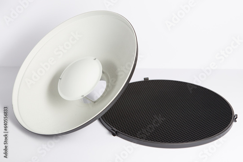 Close up on a potographic beauty dish with grid, background is white.