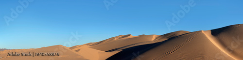 Horizontal panorama desert sand dunes and blue sky photo