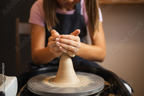 A girl working with clay on a Potter's wheel close up. Tradition