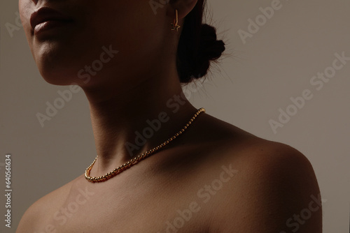 Beauty close-up portrait of woman with a healthy skin wearing tiny necklace.