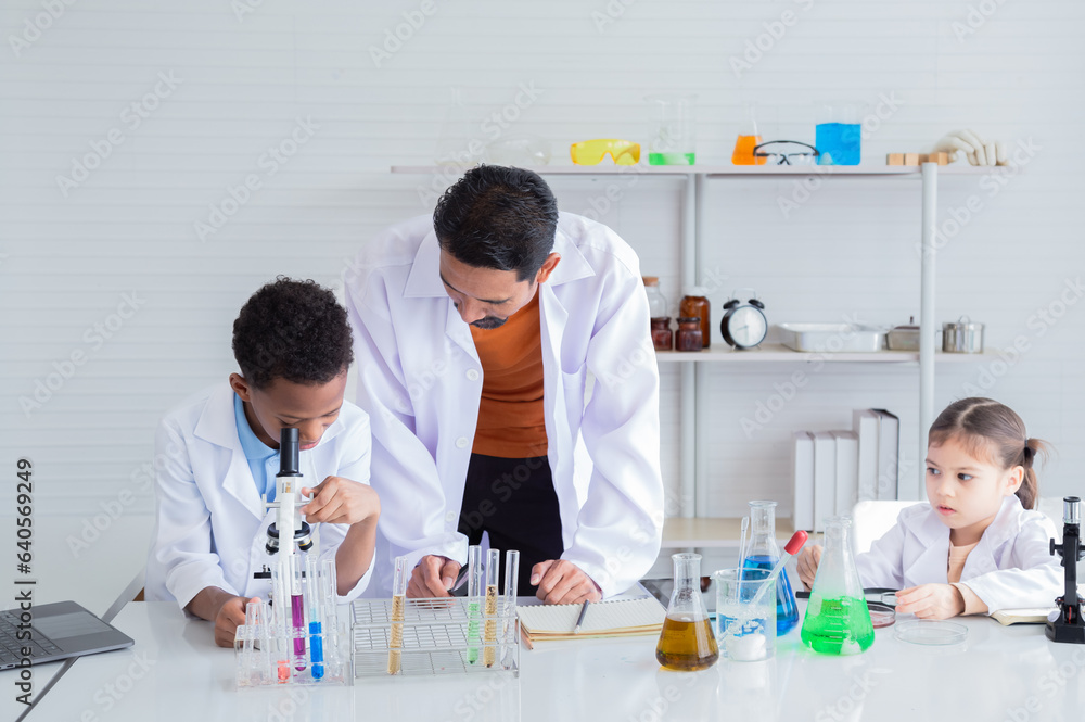 Group of multicultural African boy and elementary students girl kids friend wearing lab coat uniforms using microscope with teacher in laboratory room, lifestyle learning education in science class Group of multicultural African boy and elementary students girl kids friend wearing lab coat uniforms using microscope with teacher in laboratory room, lifestyle learning education in science class