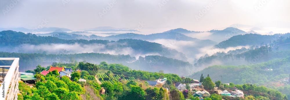 Sea fog on a mountain in the morning. Waves of clouds in the background peaks covered with pine forest and organic vegetable farm providing local food