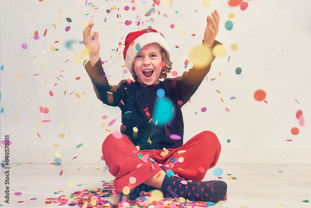 Fototapeta premium Happy boy in Santa hat under confetti