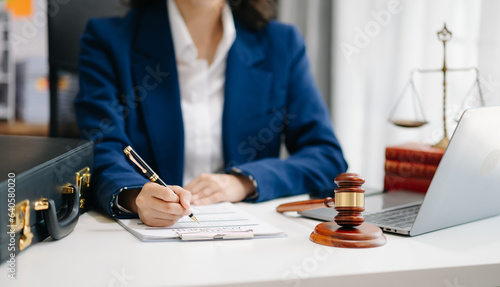 justice and law concept. Female judge in a courtroom the gavel, working with smart phone and laptop and digital tablet computer on white table
