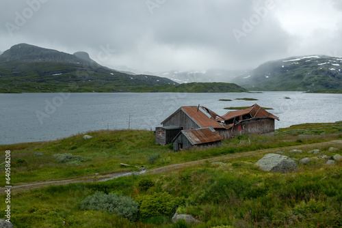 Norwegian Mountain Landscape with Damaged Building and Majestic Mountain in Scenic Nature of Haukelifjell by road E134. photo