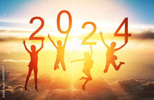 Happy new year card 2024. Silhouette of children girls are  jumping over cloud with sunrise or sunset sky background. Four Kids holding the number 2024 with fantastic sky, New year's concept.