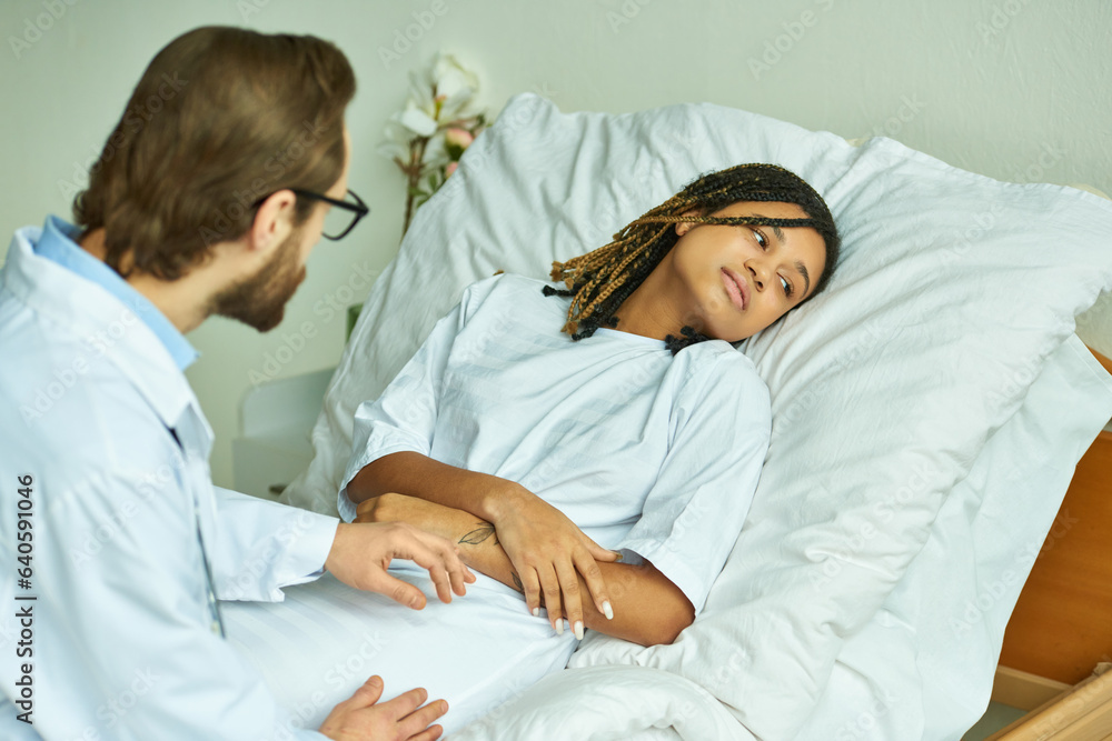 doctor in white coat holding hand of sad african american woman, private ward, miscarriage concept doctor in white coat holding hand of sad african american woman, private ward, miscarriage concept