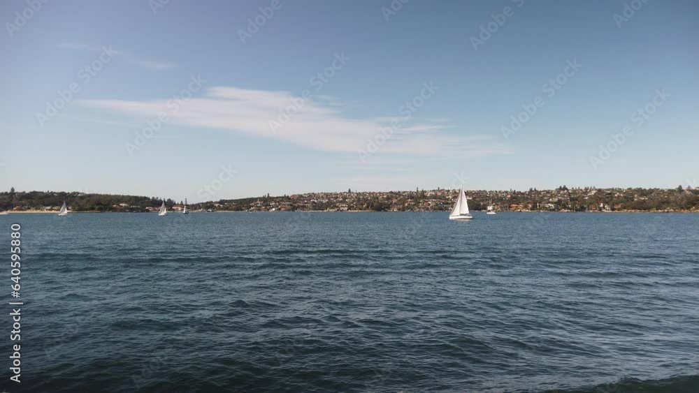 Slow motion cityscape of sailing boats navigating the beautiful blue waters of Sydney Harbour showcasing the Australian culture and lifestyle. Slow motion cityscape of sailing boats navigating the beautiful blue waters of Sydney Harbour showcasing the Australian culture and lifestyle.