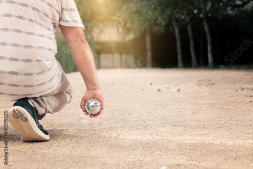 Cuadro en lienzo man throwing a petanque ball in an urban garden