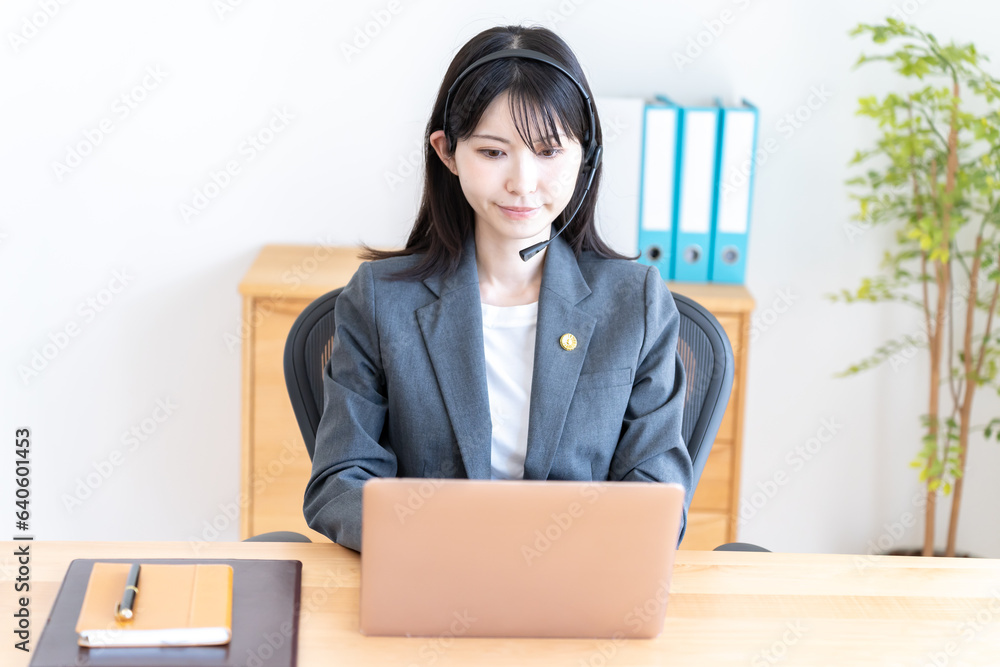 ヘッドセットをつけて話をする女性弁護士 ヘッドセットをつけて話をする女性弁護士