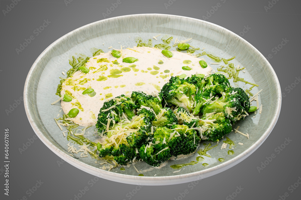 Steamed brocolli with cream sauce and parmesan. Isolated on a white background. Steamed brocolli with cream sauce and parmesan. Isolated on a white background.