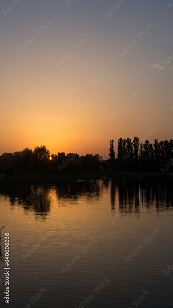 Orange sunset near the calm water of the lake