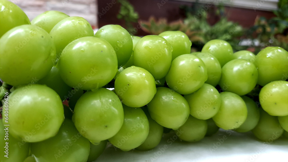 Muscat fresh green grapes stacked in heaps with blurry background. Muscat fresh green grapes stacked in heaps with blurry background.