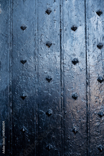 Close up of blue color security wooden door with metal elements. Safety and security in ancient time theme. Protection of family and wealth.