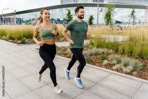 Athletes exercise for health. Happy people jogging together. Runners partners training in sports clothes and running shoes. Use a fitness watch and a cardio app.
