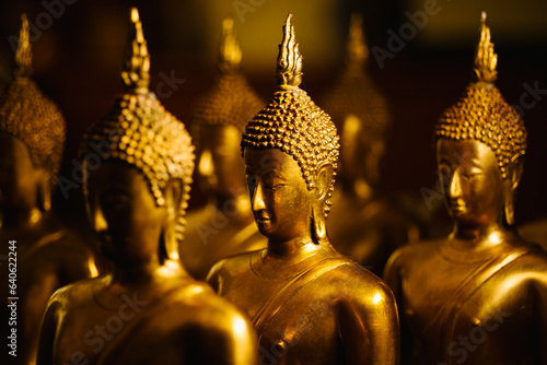 Closeup head shot of Buddha statue on yellow light background