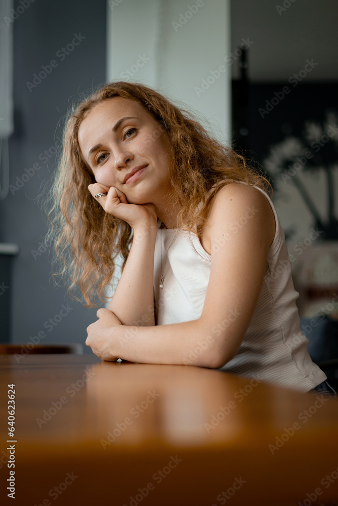 A red-haired girl in a cafe waiting for a drink A red-haired girl in a cafe waiting for a drink
