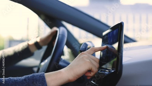 Unrecognizable man which typing needed coordinates on navigator touchscreen inside his auto. Unknown man sitting in front of the handlebar of his own luxury auto and applying navigator