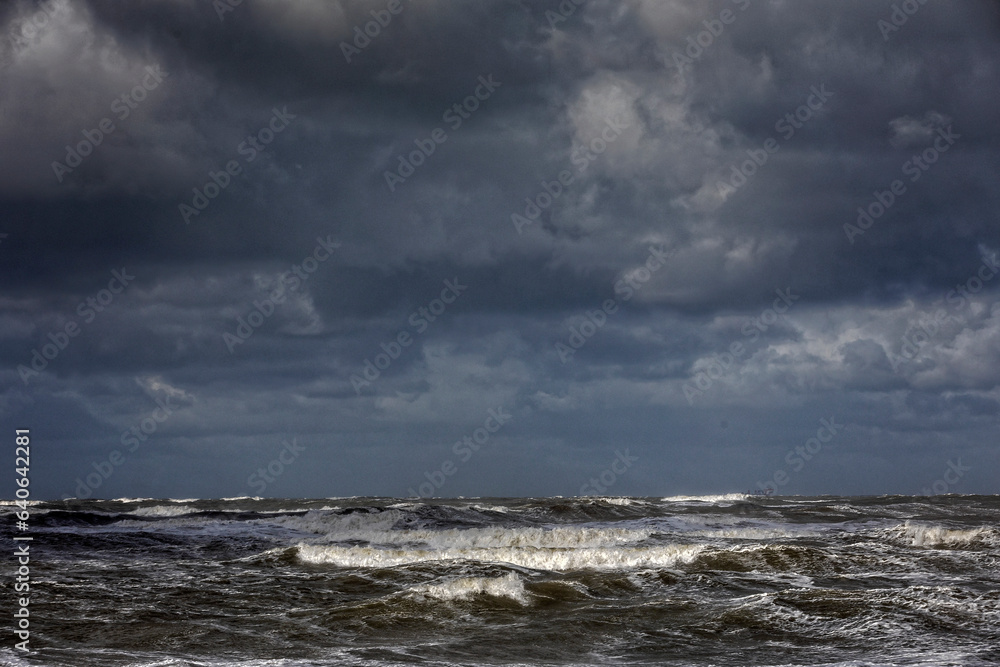 stormy weather with dark clouds and rough waves on the North Sea along the Dutch coast