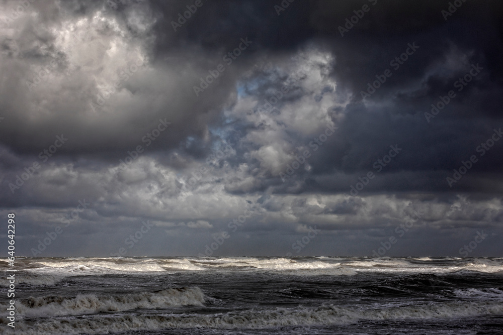 stormy weather with dark clouds and rough waves on the North Sea along the Dutch coast