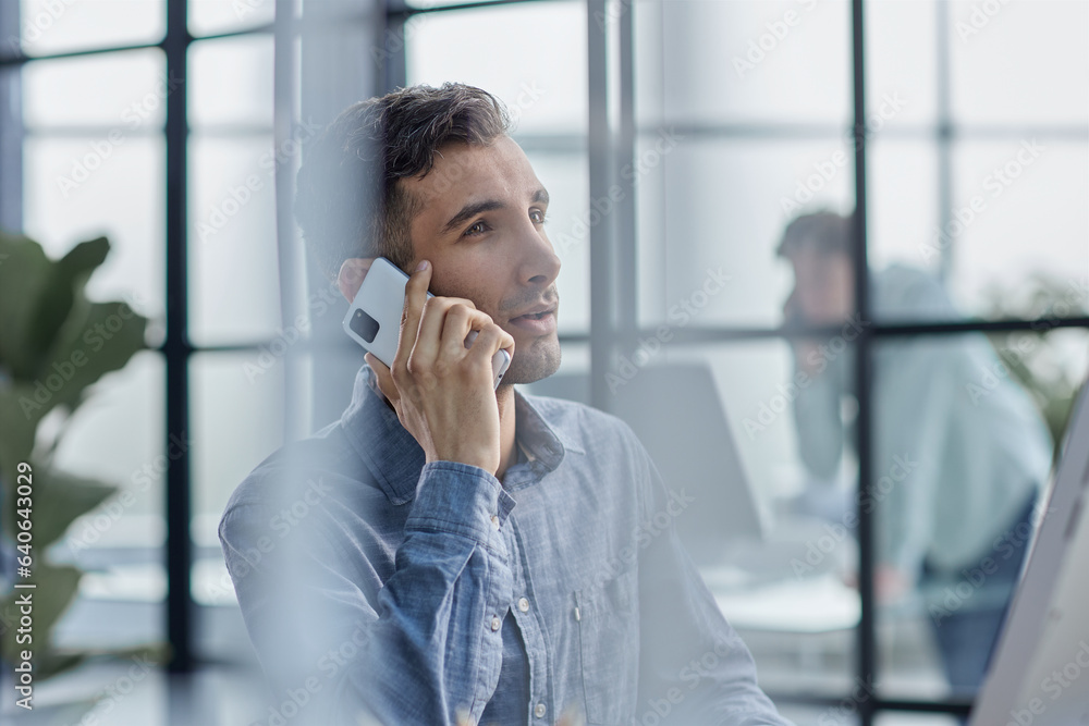 Businessman shopping over the phone in an office Businessman shopping over the phone in an office