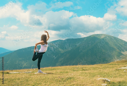 Meditation and gymnastics in a beautiful mountain landscape, at high altitude. A beautiful woman practices Yoga exercises.