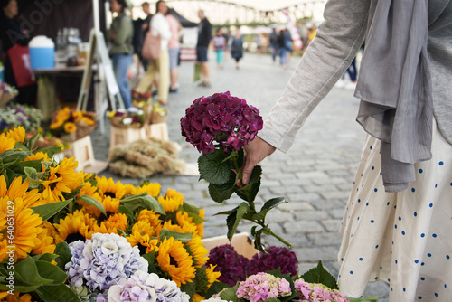 Foto Woman selecting fresh flowers at the farmers' market
