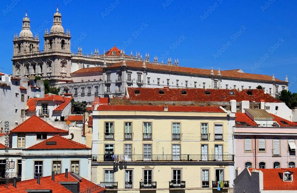 Photo with the view of the Mosteiro de Sao Vicente de Fora and colored houses in the foreground in the Portuguese capital, Lisbon
