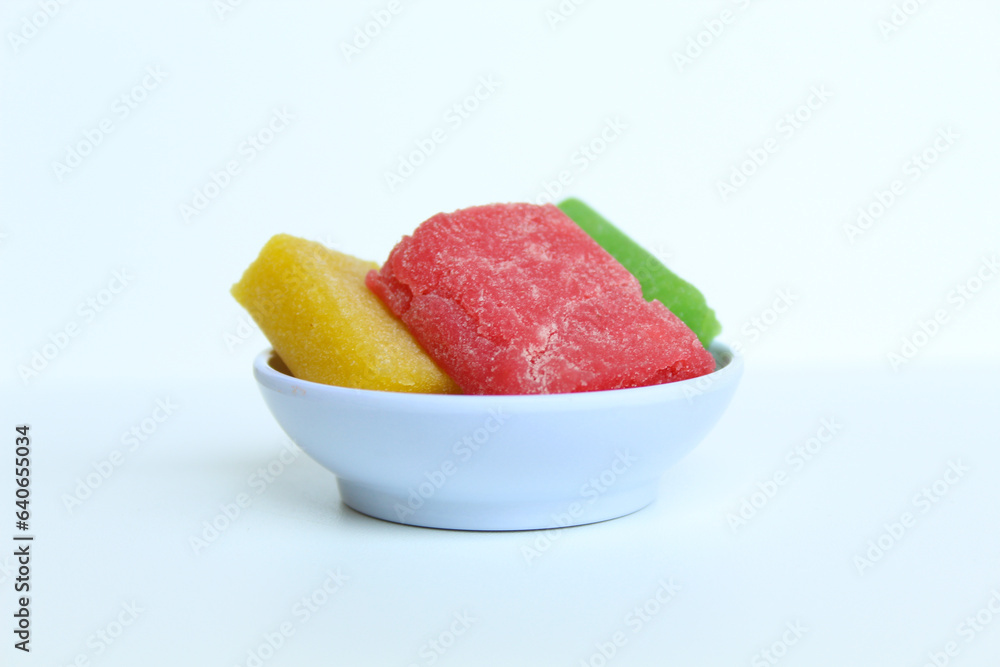 Yangko is traditional snack from Yogyakarta, Indonesia. Made from glutinous rice powder. Colorful yangko on plate plate, isolated on white background Yangko is traditional snack from Yogyakarta, Indonesia. Made from glutinous rice powder. Colorful yangko on plate plate, isolated on white background