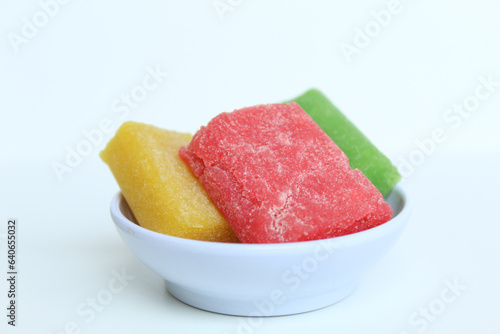 Yangko is traditional snack from Yogyakarta, Indonesia. Made from glutinous rice powder. Colorful yangko on plate plate, isolated on white background