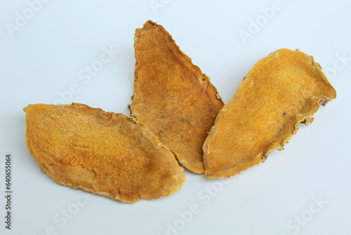 Sliced and dried rhizome of Curcuma zanthorrhiza, or temulawak. Isolated on white background. Flat lay or top view photo