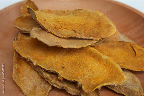 Sliced and dried rhizome of Curcuma zanthorrhiza, or temulawak, or Java ginger, or Javanese ginger, or Javanese turmeric. Isolated on white background photo