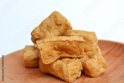 Fried tofu on wooden plate, on white background photo