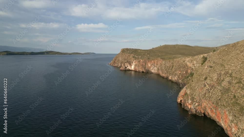 Beautiful view of mountain rocks and blue clear water of the small sea of Lake Baikal. Unique summer views of the nature of Olkhon island. The view from the drone Beautiful view of mountain rocks and blue clear water of the small sea of Lake Baikal. Unique summer views of the nature of Olkhon island. The view from the drone