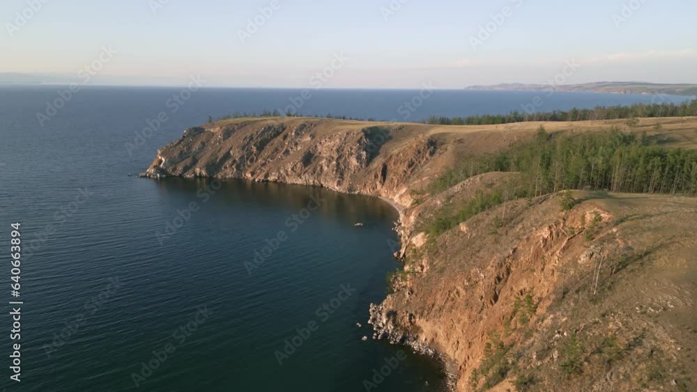Beautiful view of mountain rocks and blue clear water of the small sea of Lake Baikal. Unique summer views of the nature of Olkhon island. The view from the drone Beautiful view of mountain rocks and blue clear water of the small sea of Lake Baikal. Unique summer views of the nature of Olkhon island. The view from the drone