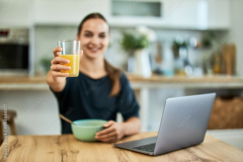 Portrait of a smiling woman with a blurred face, showing a glass with orange juice. Portrait of a smiling woman with a blurred face, showing a glass with orange juice.